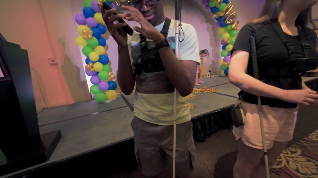 A young competitor films with a phone amid the bustle of the Braille Challenge.